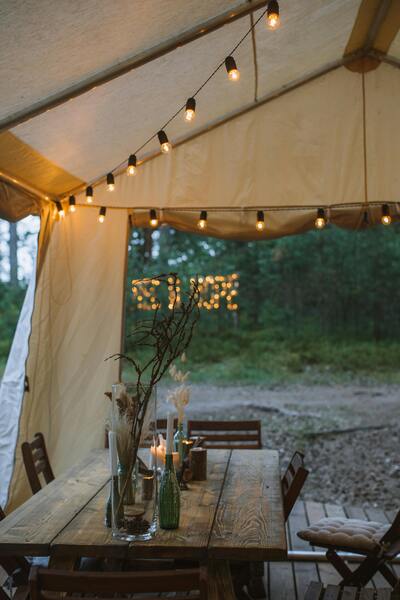 Brown Wooden Table With Chairs Outside of Safari Glamping tent.