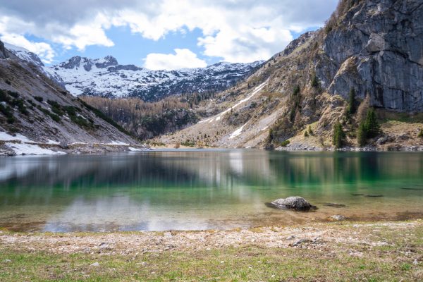 Mountain lake with snow-capped peaks and turquoise water, Lake Krn, Slovenia.